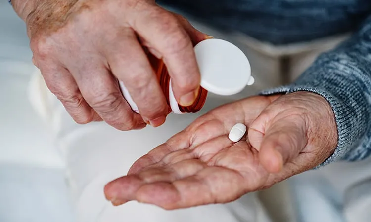 A senior taking out a pill from a bottle