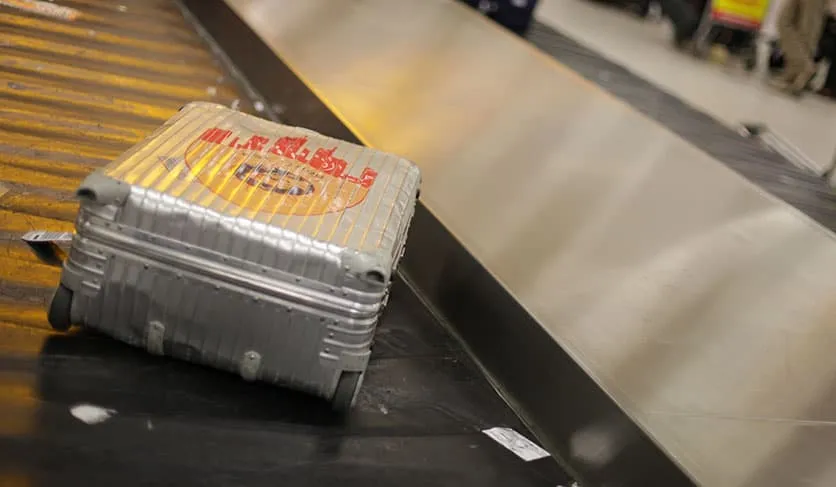 Aluminiumkoffer auf einem Gepäckförderband im Flughafen