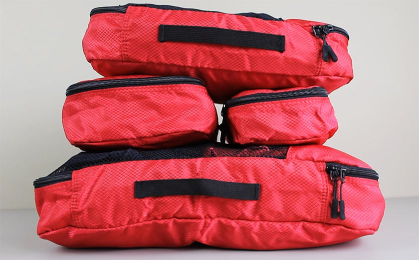 Red Amazonbasics packing cubes packed full stacked in a pile