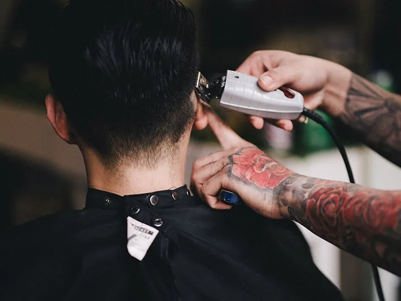 Barber using a hair trimmer on a client