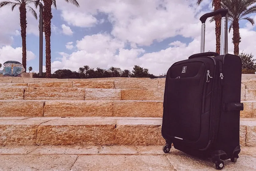 A Black travelpro maxlite 5 fabric carry-on on stairs