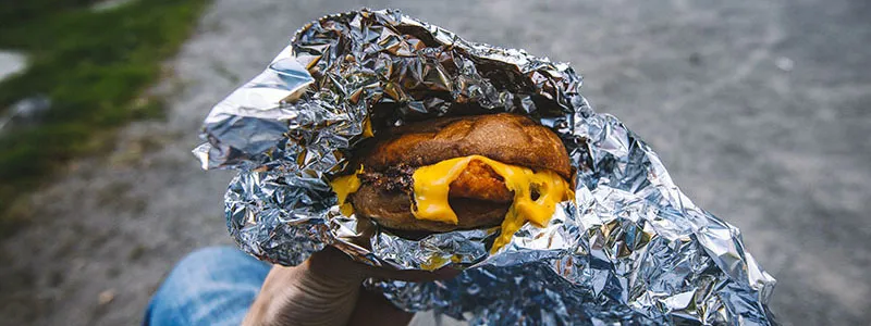 A burger wrapped in aluminum tin foil