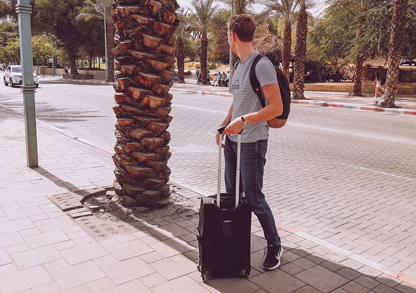 a man using a carry-on suitcase in southern europe