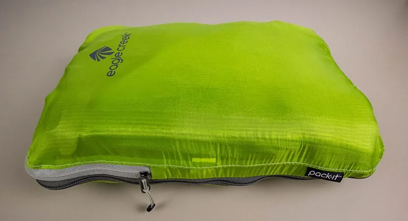 Clothes packed in a single green eagle creek compression cube