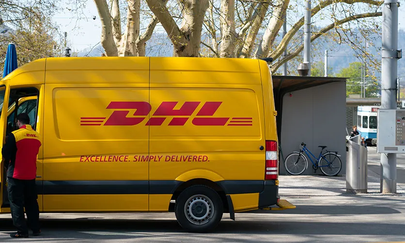 a man unloading packages from a DHL minivan