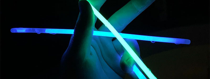 Blue and Green glow sticks held in hand