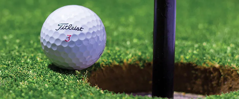 A golf ball on a green lawn