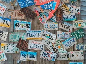Multiple US license plates on a wooden wall
