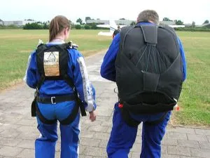 Man and woman wearing parachutes
