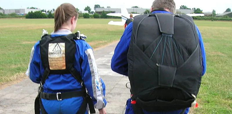 Man and woman wearing parachutes