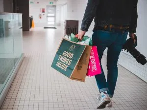 A man carrying duty free shopping bags inside an airport