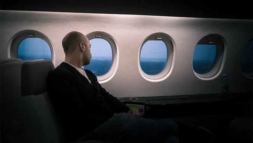 A man sitting inside a business class seat on an airplane