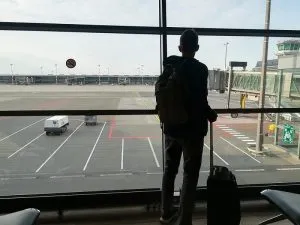 man standing in airport with luggage