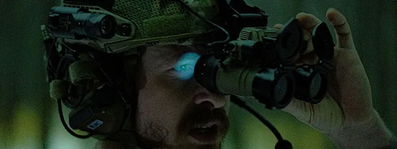 A man wearing night vision binoculars