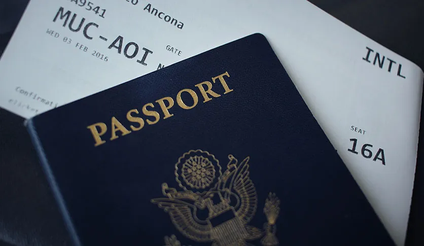 Should You Always Keep Your Passport on You When Traveling? 1 Passport next to an airline ticket