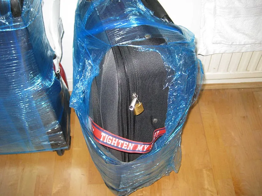 blue plastic wrap on fabric suitcase