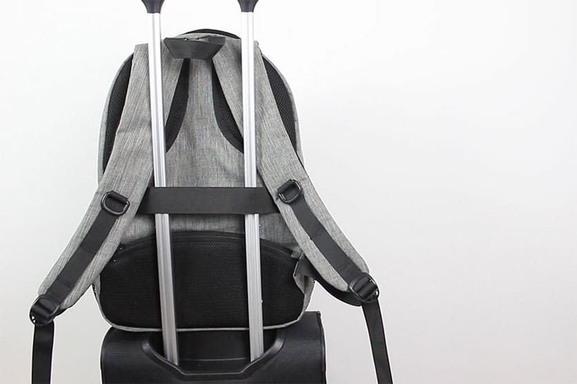Travelpro Maxlite 5 with a gray backpack on top secured around the retractable handle