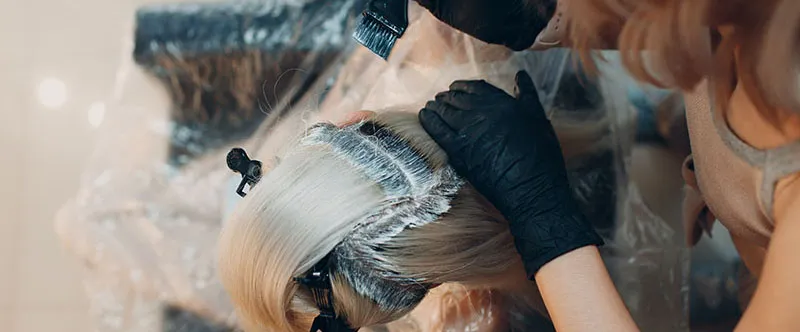 A woman applying hair dye